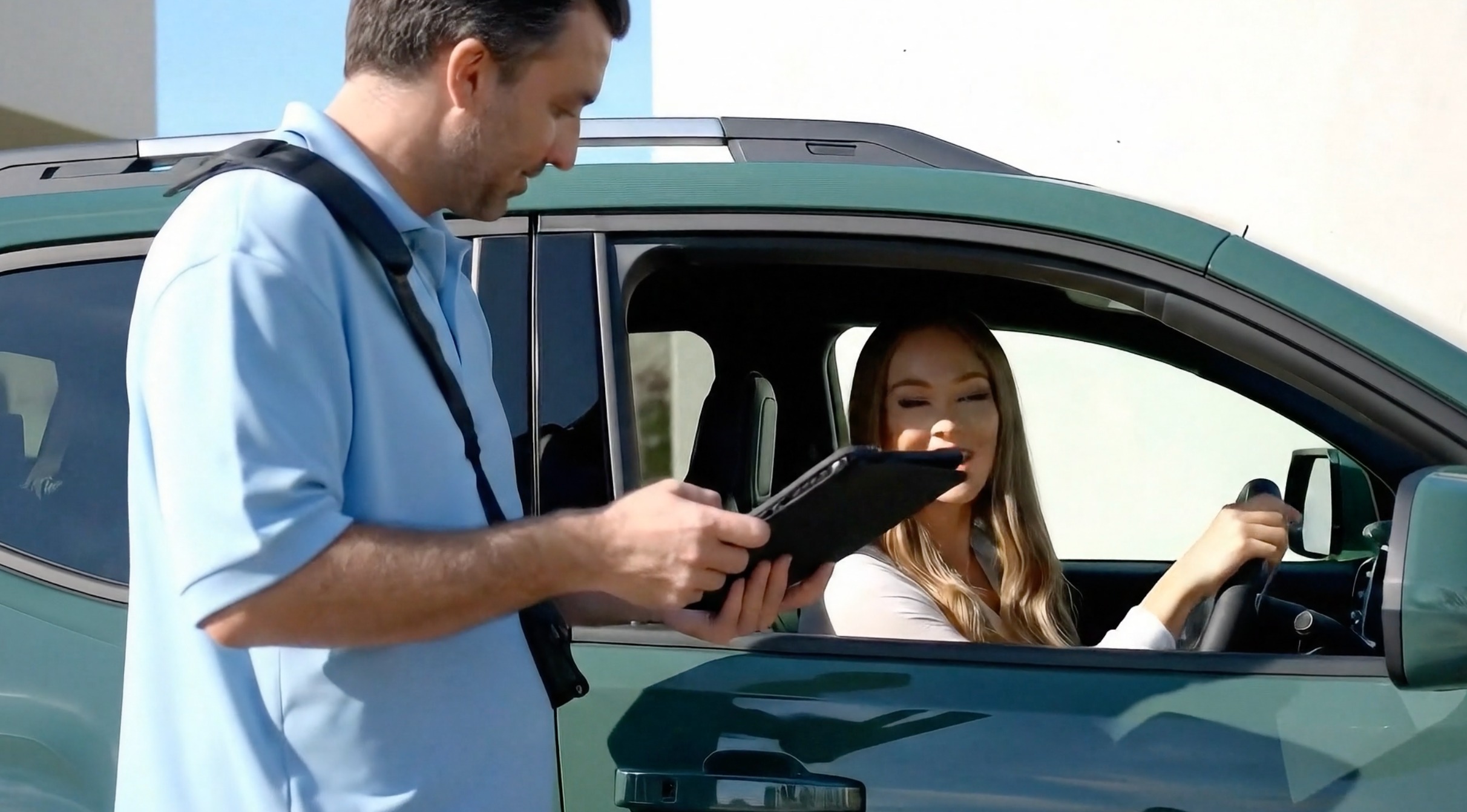 Car wash employee using FlexWash tablet with customer